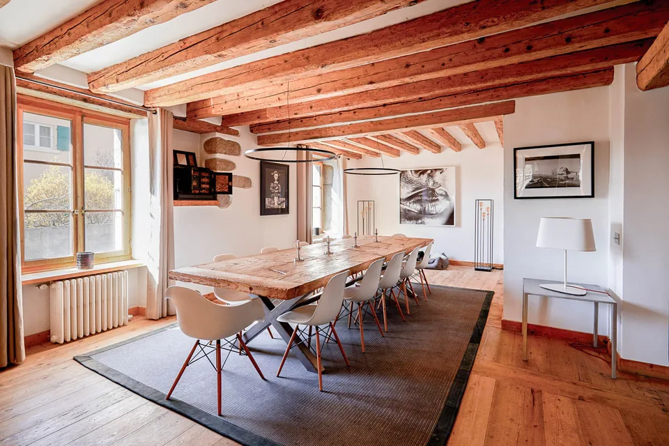 Photographie intérieure d’une salle à manger avec poutres apparentes
